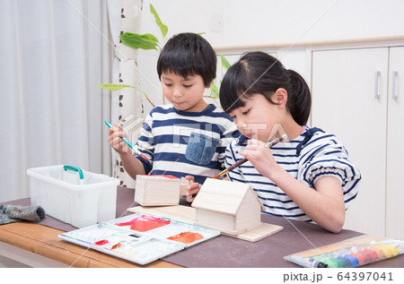 絵の具で作品に色を塗る小学生 64397041