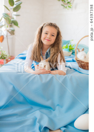 Cute girl with easter bunnies in the room decorative for the holiday. Easter mood Cute girl with easter bunnies in the room decorative for the holiday. Easter mood 64397398