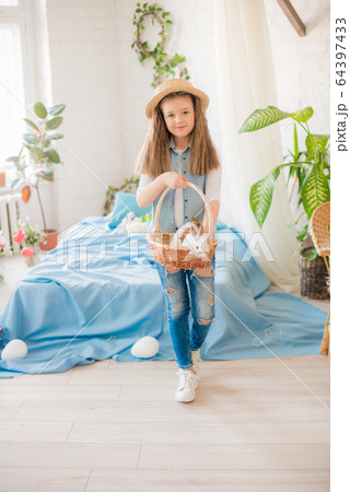 Cute girl with easter bunnies in the room decorative for the holiday. Easter mood Cute girl with easter bunnies in the room decorative for the holiday. Easter mood 64397433