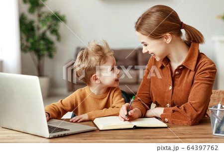 Mother and son working on remote project together. Mother and son working on remote project together. 64397762