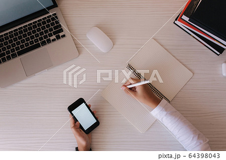 Top view of Schoolboy study at desk in his room. Boy use laptop and smartphone to writing in notebook. Books and tablet on the table. Study home during qurantine 64398043