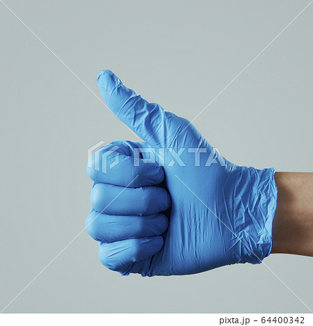 man wearing surgical gloves giving a thumb sign 64400342