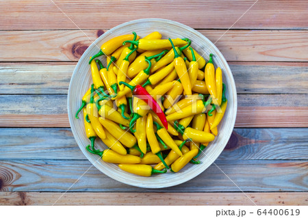 Yellow hot peppers on wooden plate Yellow hot peppers on wooden plate 64400619