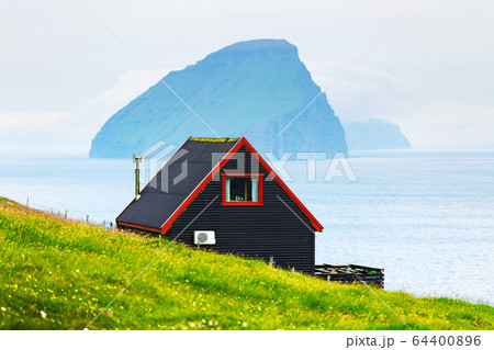 Black house on famous faroese Witches Finger Trail 64400896