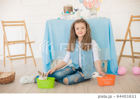Cute girl with easter bunnies in the room decorative for the holiday. Easter mood 64401631