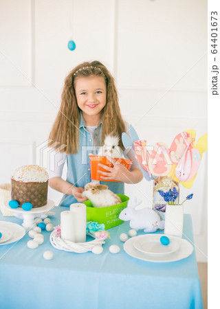 Cute girl with easter bunnies in the room decorative for the holiday. Easter mood 64401673