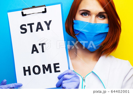 Woman holding blank with inscription stay at home calling for stop spreading covid-19. Woman holding blank with inscription stay at home calling for stop spreading covid-19. 64402001
