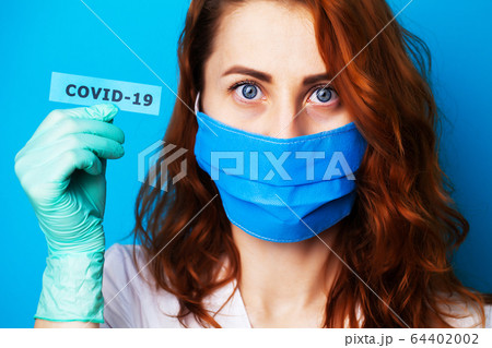 Woman in protective gloves holding inscription covid-19. Woman in protective gloves holding inscription covid-19. 64402002