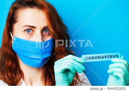 Woman in mask and protective gloves holding inscription coronavirus Woman in mask and protective gloves holding inscription coronavirus 64402003