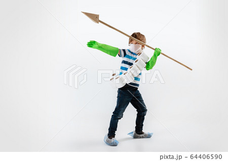 Little caucasian boy as a warrior in fight with coronavirus pandemic, with a face mask, a spear and a toilet paper bandoleer, attacking Little caucasian boy as a warrior in fight with coronavirus pandemic, with a face mask, a spear and a toilet paper bandoleer, attacking 64406590