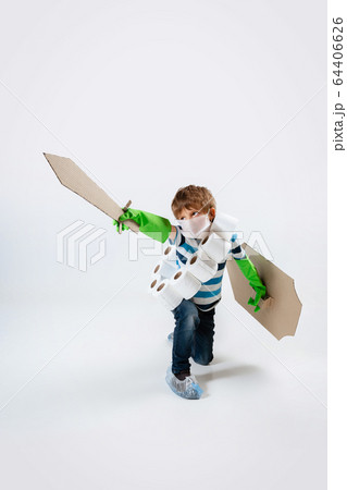 Little caucasian boy as a warrior in fight with coronavirus pandemic, with a shield, a sword and a toilet paper bandoleer, attacking 64406626