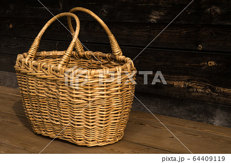 Ancient wicker basket on a wooden background. Selective focus. Free space for text. 64409119