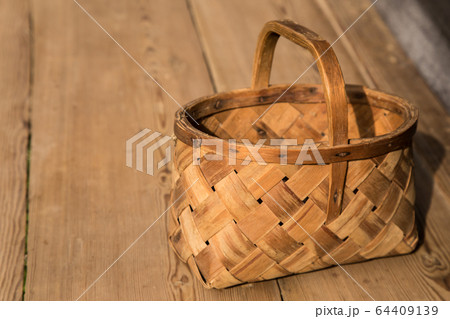 Ancient wicker basket on a wooden background. Selective focus. Free space for text. 64409139