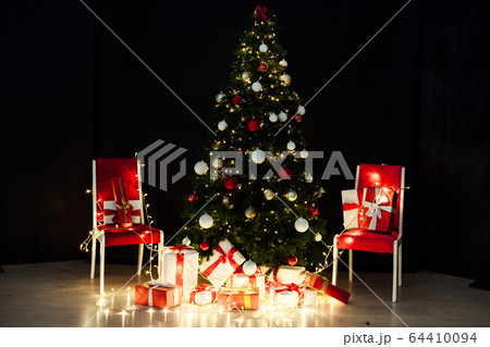 Christmas tree with lights garlands and New Year's gifts Christmas tree with lights garlands and New Year's gifts 64410094