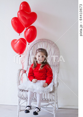 little beautiful girl on holiday with red heart-shaped balloons little beautiful girl on holiday with red heart-shaped balloons 64410673
