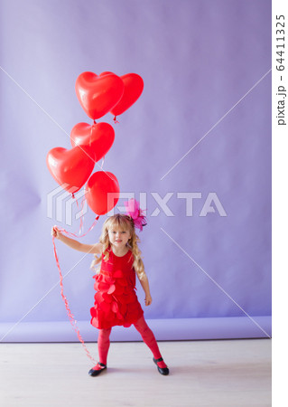 little beautiful girl on holiday with red heart-shaped balloons little beautiful girl on holiday with red heart-shaped balloons 64411325
