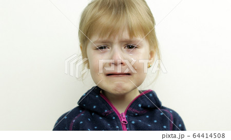 Portrait of little child girl crying with tears on her eyes. White background Portrait of little child girl crying with tears on her eyes. White background 64414508
