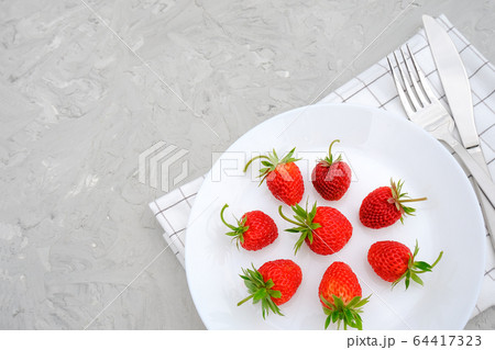 Red ripe strawberries berry on white plate, 64417323
