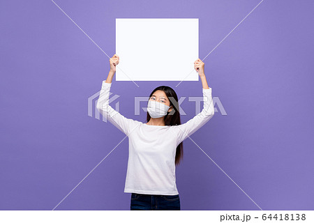 Young Asian woman wearing medical mask holding white paper 64418138