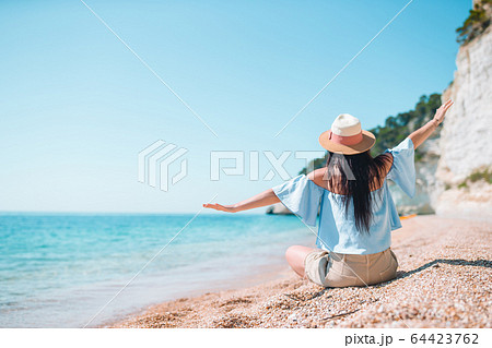 Woman laying on the beach enjoying summer holidays 64423762