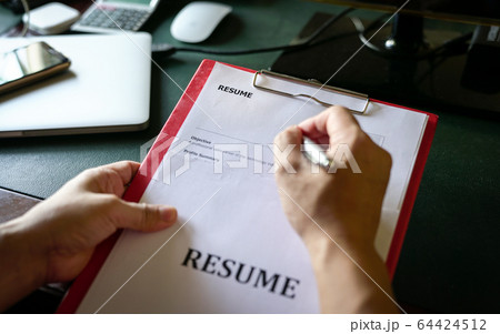 Hiring Manager reviewing resume on clipboard at 64424512