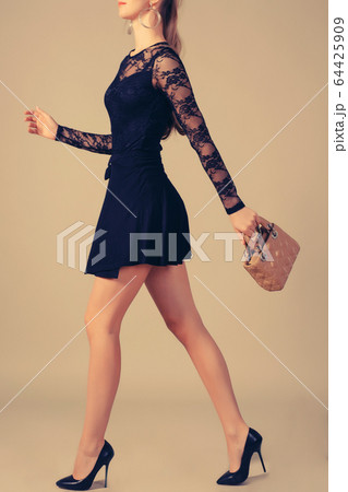 A tall, slender girl in a little black dress with 64425909