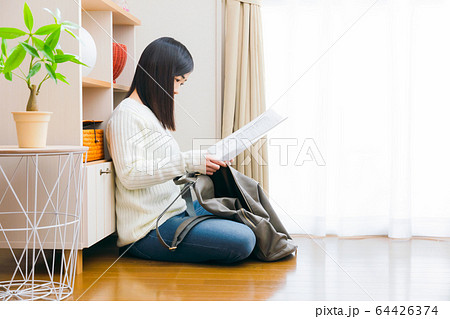 外出準備　書類を鞄に入れる女性 64426374