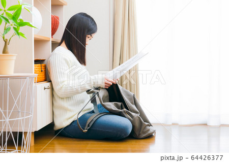 外出準備　書類を鞄に入れる女性　コピースペース 64426377