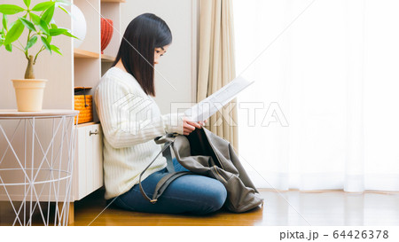 外出準備　書類を鞄に入れる女性　コピースペース　16:9 64426378