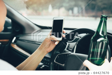 Asian men drink alcohol in the car and using Asian men drink alcohol in the car and using 64427670