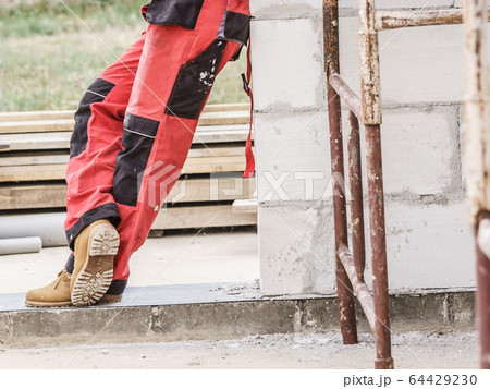 Person wearing red worker trousers 64429230