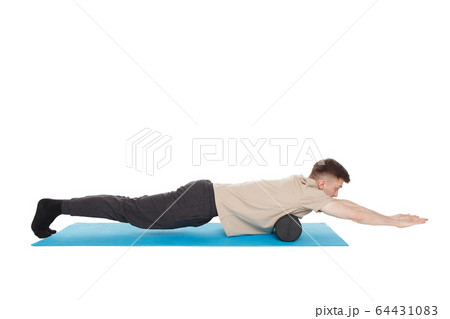 Handsome man shows exercises using a foam roller Handsome man shows exercises using a foam roller 64431083