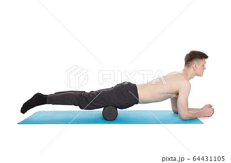 Handsome man shows exercises using a foam roller Handsome man shows exercises using a foam roller 64431105