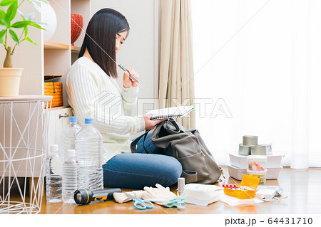 防災用品を確認する女性 不安 ノート チェックリスト コピースペース 防災用品を確認する女性 不安 ノート チェックリスト コピースペース 64431710