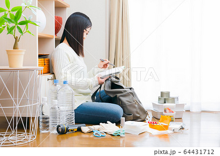 防災用品を確認する女性 ノート チェックリスト コピースペース 防災用品を確認する女性 ノート チェックリスト コピースペース 64431712