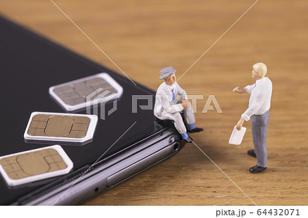 スマートフォンのSIMカードについて話す男たち スマートフォンのSIMカードについて話す男たち 64432071