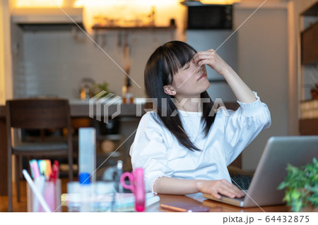 深夜まで自宅で仕事をする若い女性 深夜まで自宅で仕事をする若い女性 64432875