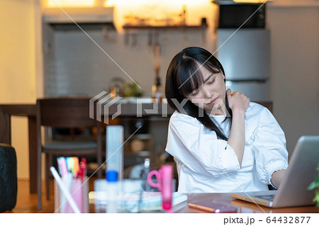 深夜まで自宅で仕事をする若い女性 深夜まで自宅で仕事をする若い女性 64432877