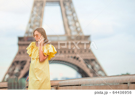 Beautiful woman in Paris background the Eiffel tower during her vacation 64436956