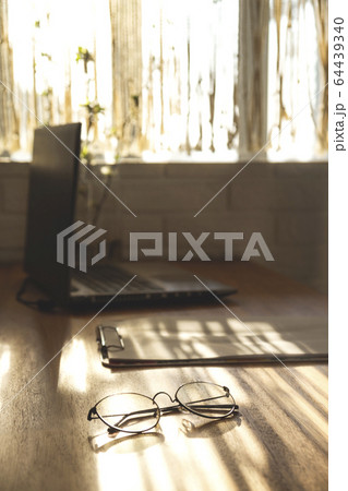 Minimalistic workplace at home on a wooden table in the shadows. Minimalistic workplace at home on a wooden table in the shadows. 64439340