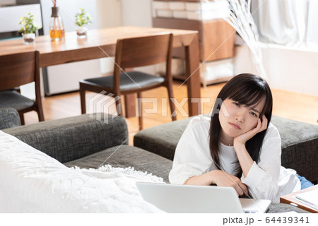 リビングで考え込む若い女性 64439341