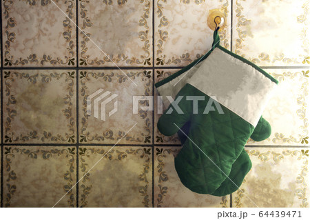 Green oven mitts hang on old-fashioned wall with pattern tiles antique design Green oven mitts hang on old-fashioned wall with pattern tiles antique design 64439471