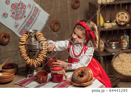 Adorable girl pouring tea from samovar 64441295