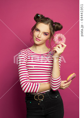 Smiling woman with donut on colorful pink Smiling woman with donut on colorful pink 64441951