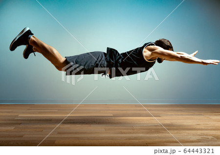 A man does functional exercises in the gym on a gray background. Fitness concept, sports body, body positive, copy space A man does functional exercises in the gym on a gray background. Fitness concept, sports body, body positive, copy space 64443321