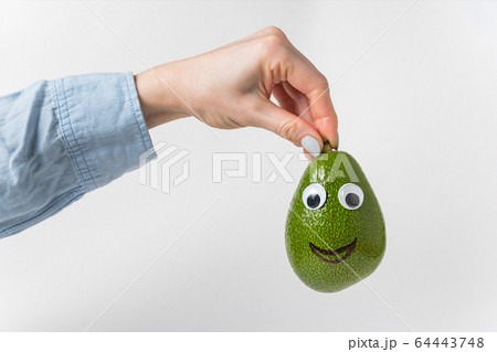 hand is holding avocado smile over white hand is holding avocado smile over white 64443748
