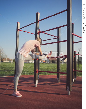 Woman Stretching in the Park 64444284
