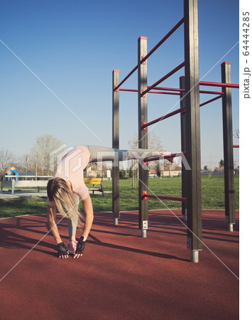 Woman Stretching in the Park 64444285