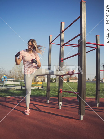Woman Stretching in the Park 64444286