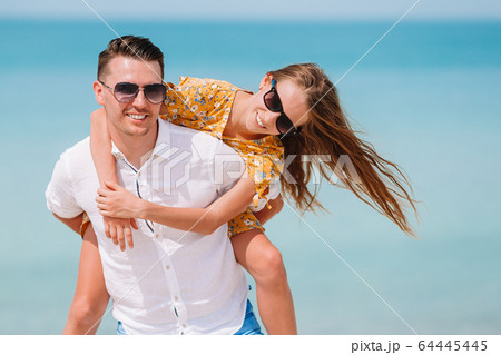Little girl and happy dad having fun during beach vacation Little girl and happy dad having fun during beach vacation 64445445